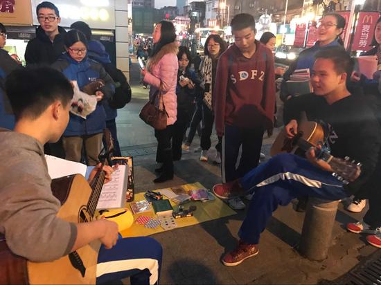 夜幕降临，义卖行动还在继续。同学们不畏寒冷想筹集更多善款。